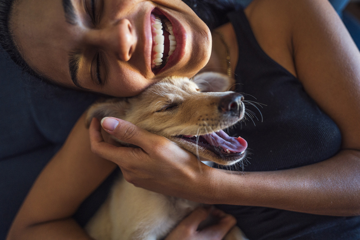 Beautiful young woman playing with a puppy