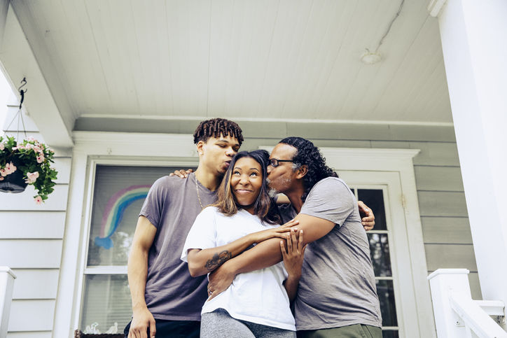 Portrait of father and adult offspring on front porch