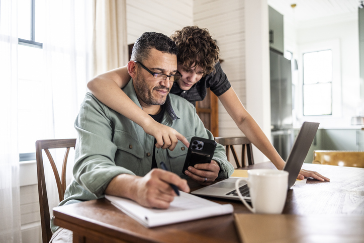 Father working from home with teenage son